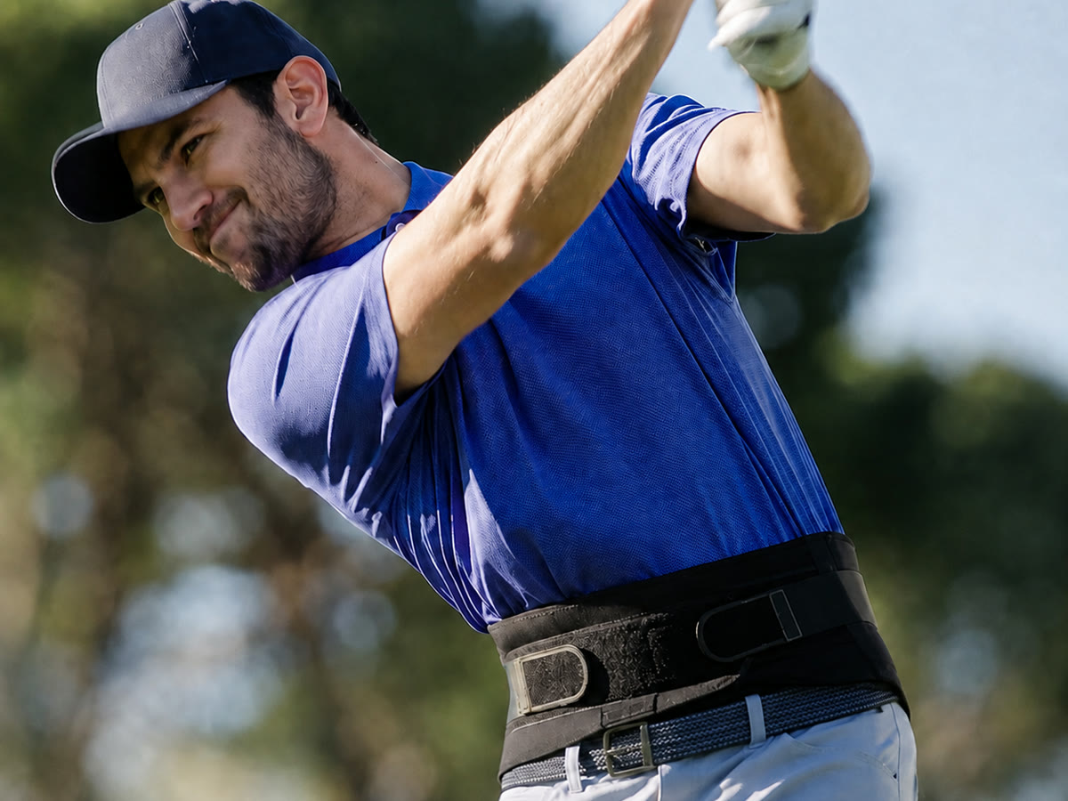 Golfer mid-swing wearing a Copper Fit back brace